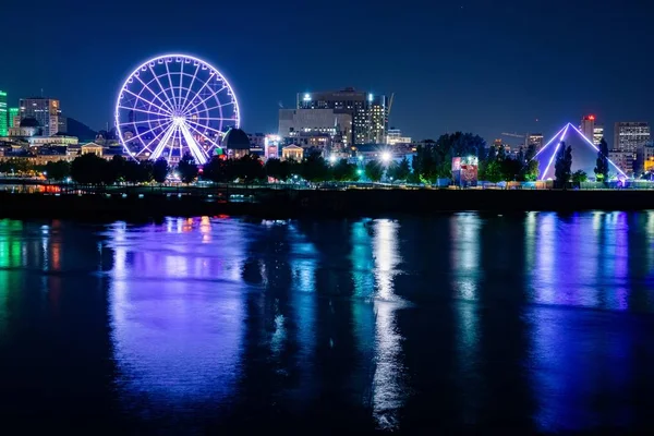 Skyline noturno no Parque Dieppe com roda gigante iluminada e reflexos claros sobre o rio — Fotografia de Stock