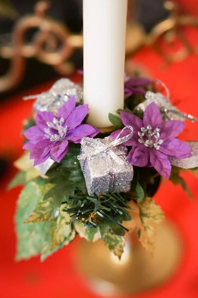 Vertical shot of a white candle in a holder decorated with tiny flowers — Stock Photo, Image