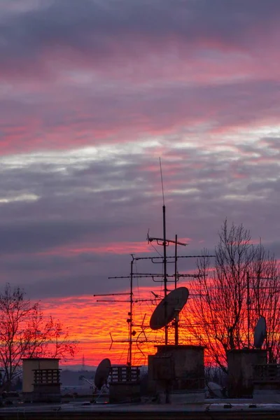 Paesaggio di tramonto in una nuova zona con una silhouette di antenne in un vecchio edificio — Foto Stock