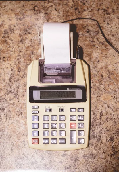 Foto de cierre de una calculadora de escritorio con cinta de papel. —  Fotos de Stock