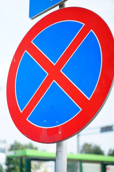 Nahaufnahme eines roten und blauen Verkehrsschildes im Sonnenlicht mit verschwommenem Hintergrund — Stockfoto