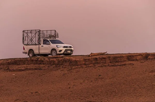 Lövöldözés a sivatagban haladó fehér kocsiról ketreccel a hátuljában. — Stock Fotó