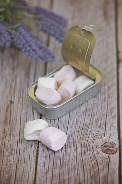 Sluiten van marshmallow in een tonijnblik op de houten tafel onder het licht — Stockfoto