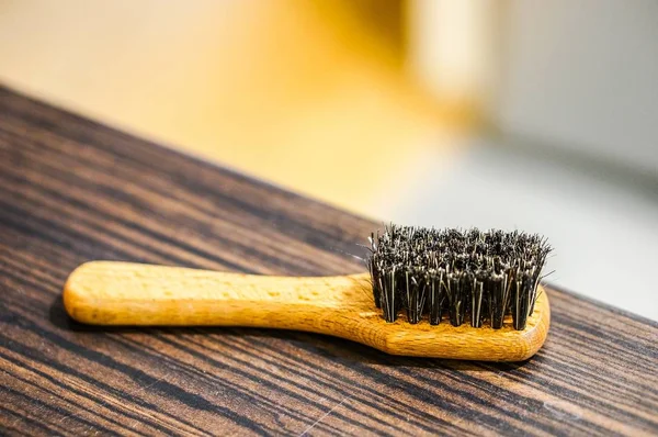 Nahaufnahme einer Stahldrahtbürste auf einem Holztisch — Stockfoto