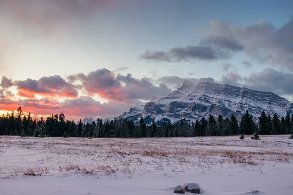 美しい夕日の空の下で雪に覆われた山岳風景の息をのむような景色 — ストック写真