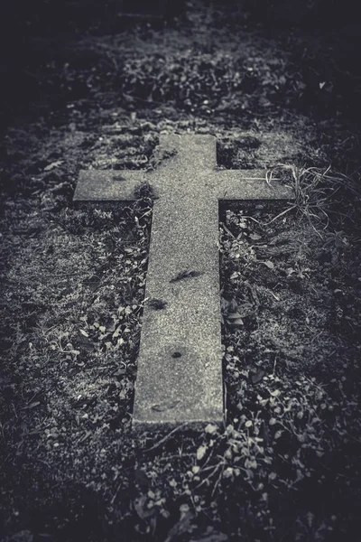 Κάθετη βολή ενός πέτρινου σταυρού στο έδαφος σε γκρι — Φωτογραφία Αρχείου