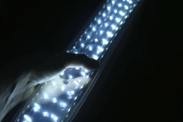 Hand hält eine wiederaufladbare LED-Laterne im Dunkeln — Stockfoto
