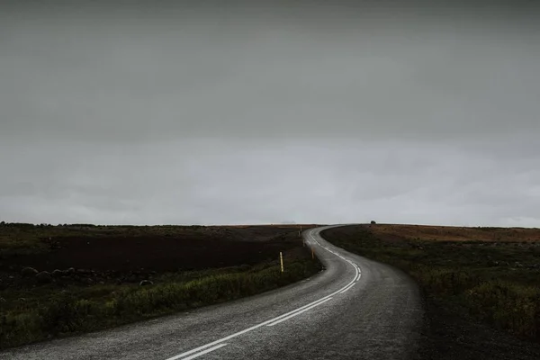 Een Lange Bochtige Weg Het Midden Van Een Groen Veld — Stockfoto