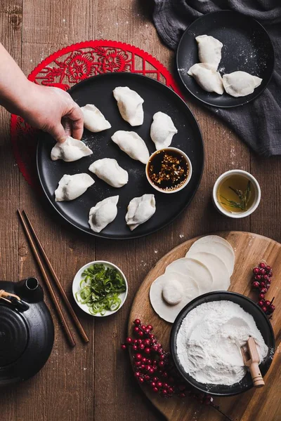 中国传统饺子放在盘子里 筷子放在木桌上的垂直镜头 — 图库照片