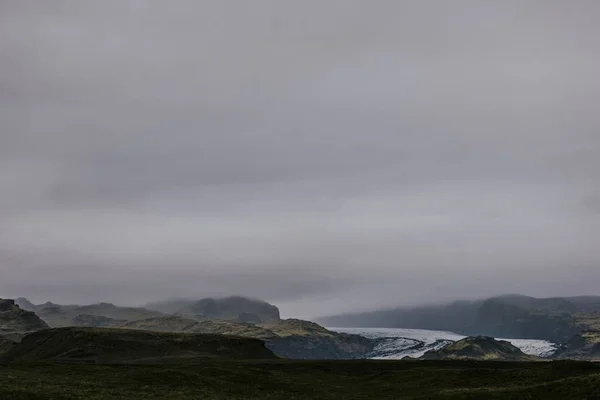 A beautiful scenery of a landscape with hills on a foggy day