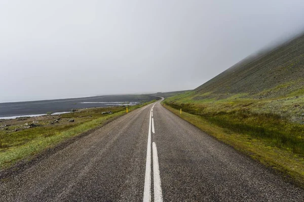 Een Lege Weg Bij Bergen Onder Een Mistige Hemel — Stockfoto