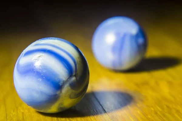 Egy Közeli Felvétel Két Örvénylő Fehér Kék Golyóról Egy Asztal — Stock Fotó
