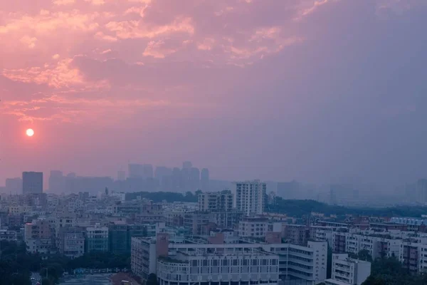 夕方のピンク色の夕焼けの空の下の都市 — ストック写真