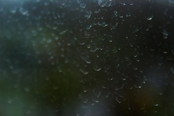 在背景模糊的尘土飞扬的窗户上 有几滴干雨滴的特写镜头 — 图库照片