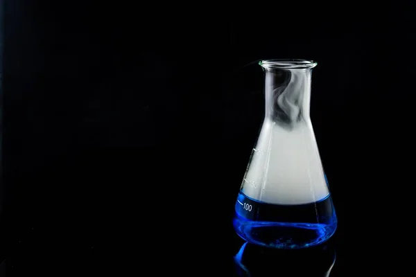 Химический Стакан Наполненный Голубой Водой Дымом Черной Поверхности — стоковое фото