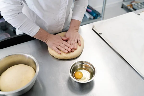 A woman cook making a cake from the dough and an egg