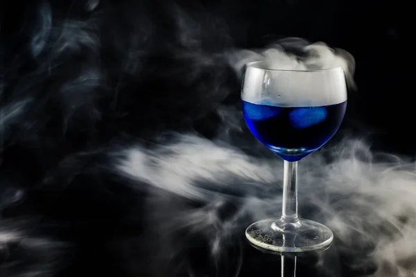 Primer Plano Una Copa Vino Llena Líquido Azul Mientras Fuma — Foto de Stock