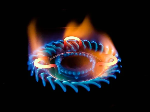 A turned on gas on a cooker in a darkness