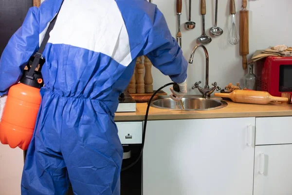 Людина в блакитному костюмі і протигазова маска, що робить санітарний огляд на кухні — стокове фото