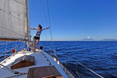 `PUERTO VARAS, CHILE - Feb 02, 2007: young woman on a yacht at Llanquihue Lake clipart