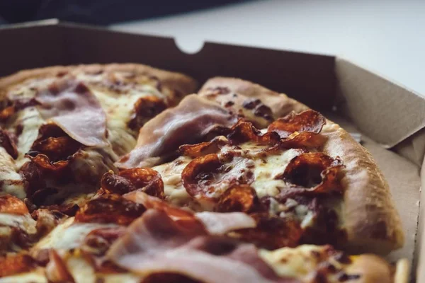 Close Uma Pizza Com Bacon Uma Caixa Sob Luzes Mesa — Fotografia de Stock