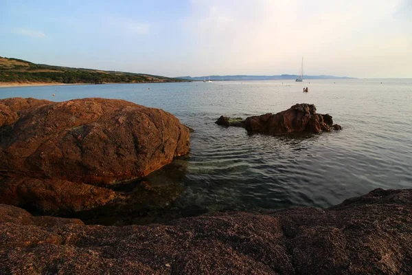 Bonito tiro do mar cercado por um monte de formações rochosas em um dia de sol — Fotografia de Stock