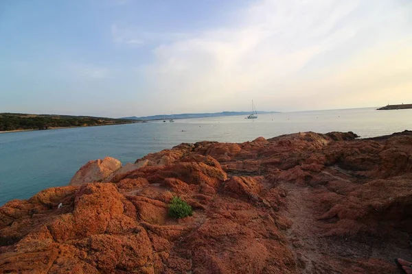 Bonito tiro do mar cercado por um monte de formações rochosas em um dia de sol — Fotografia de Stock