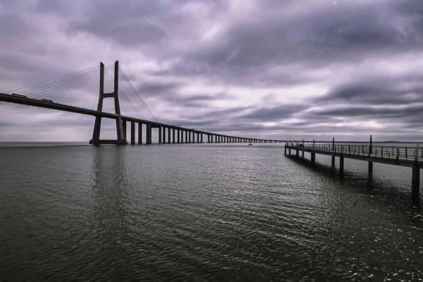 Мост Васко да Гама с темными облаками в Сакавеме, Португалия — стоковое фото