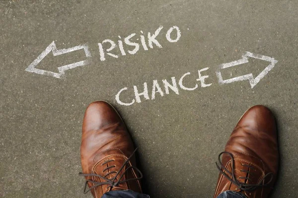 Mann blickt auf die Wörter "RISIKO" und "CHANCE" (Risiko und Chance)) — Stockfoto