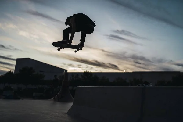 Nízký Úhel Záběru Muže Skateboarding Prázdném Skateparku Pod Zataženou Oblohou — Stock fotografie