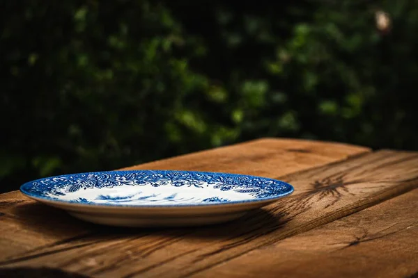 Eine Nahaufnahme Eines Leeren Blau Verzierten Porzellantellers Auf Einem Holztisch — Stockfoto
