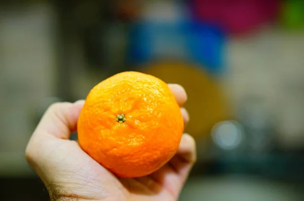 Tiro Close Uma Mão Segurando Uma Fruta Laranja — Fotografia de Stock