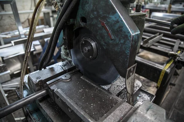 背景がぼんやりとした照明の下で工場内の古い金属切断機の閉鎖 — ストック写真
