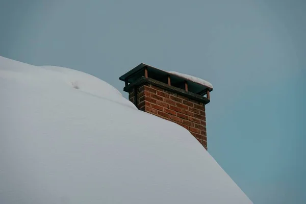Снимок Дома Низким Углом Покрытого Снегом Дымоходом Красного Кирпича — стоковое фото