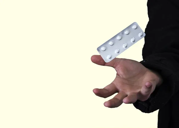 Ένα Πακέτο Άσπρα Χάπια Πάνω Από Δάχτυλα Ενός Ατόμου — Φωτογραφία Αρχείου