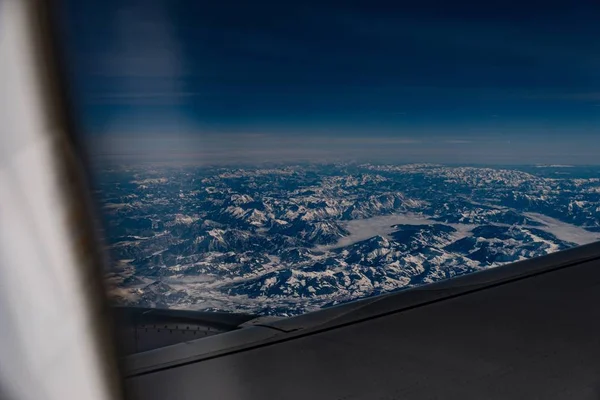 Uma Foto Cadeias Montanhas Uma Janela Avião Parcialmente Obstruída Por — Fotografia de Stock