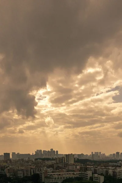 日没時にオレンジ色の空の下の都市の建物の垂直空中ショット — ストック写真