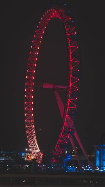 Een Verticaal Shot Van Een Grote Cirkelvormige Draaiende Draaimolen Nachts — Stockfoto