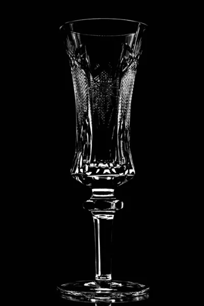 黒を背景にライトの下にシャンパングラスのグレースケール — ストック写真