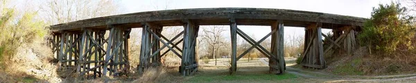 Zdjęcie Panoramiczne Drewnianego Mostu Kolejowego Otoczonego Krzakami — Zdjęcie stockowe