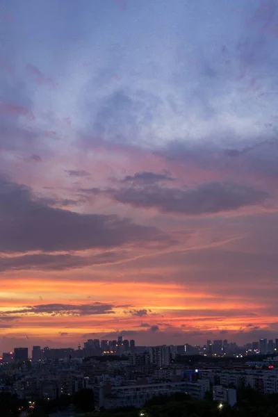 日没時にオレンジ色のピンク色の空の下で都市の建物の垂直空中ショット — ストック写真