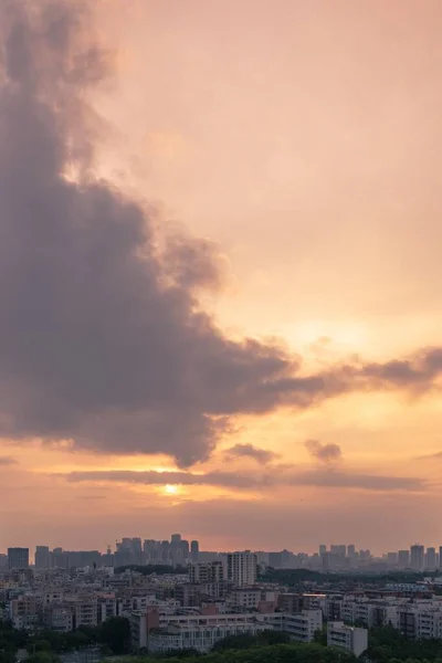 日没時にオレンジ色のピンク色の空の下で都市の建物の垂直空中ショット — ストック写真