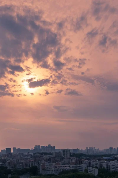 日没時にピンクの曇り空の下で都市の建物の垂直空中ショット — ストック写真