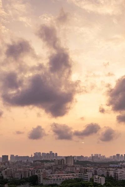 Pionowy Antenowy Strzał Wielkiego Miasta Pod Pomarańczowym Niebem Podczas Zachodu — Zdjęcie stockowe