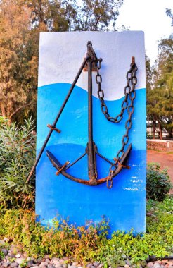 A vertical shot of an iron anchor on a small blue wall in the Canary Islands clipart