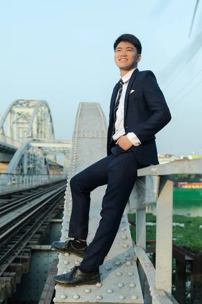 Ένας Νεαρός Ασιάτης Ακουμπά Μια Γέφυρα Χαμογελώντας Και Ατενίζοντας Μέλλον — Φωτογραφία Αρχείου