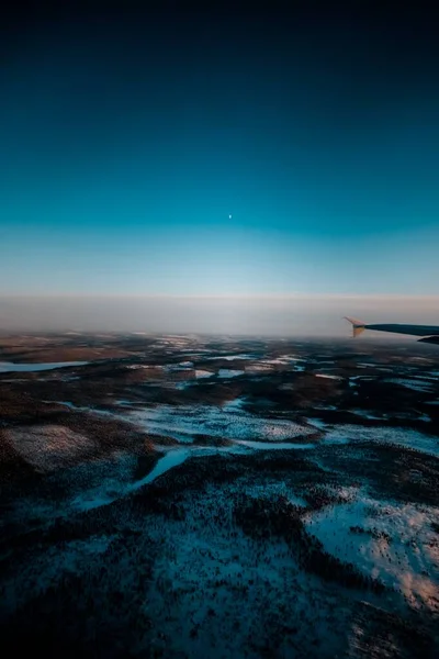 Piękne Ujęcie Skrzydła Samolotu Przez Okno Nad Pokrytym Śniegiem Krajobrazem — Zdjęcie stockowe