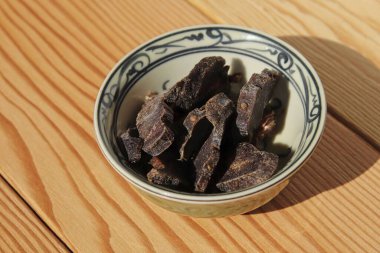 Biltong (dried meat) on a wooden board, this is a traditional food snack that can be found in South Africa. clipart