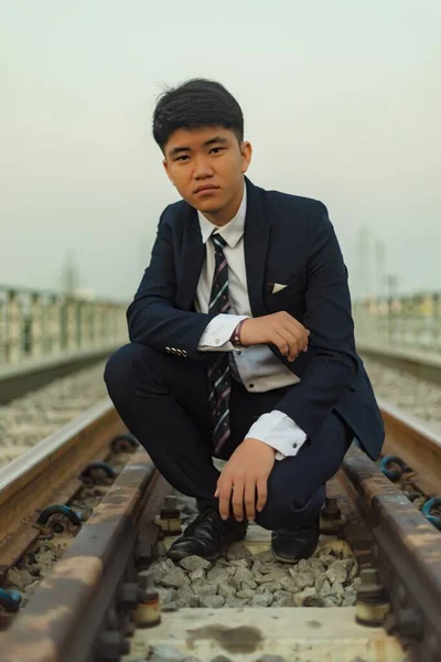 Ung Asiatisk Man Kostym Hukad Mitten Järnväg Tittar Bort — Stockfoto