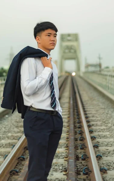 Mladý Asijský Obchodník Který Stojí Uprostřed Železnice Přes Rameno Drží — Stock fotografie